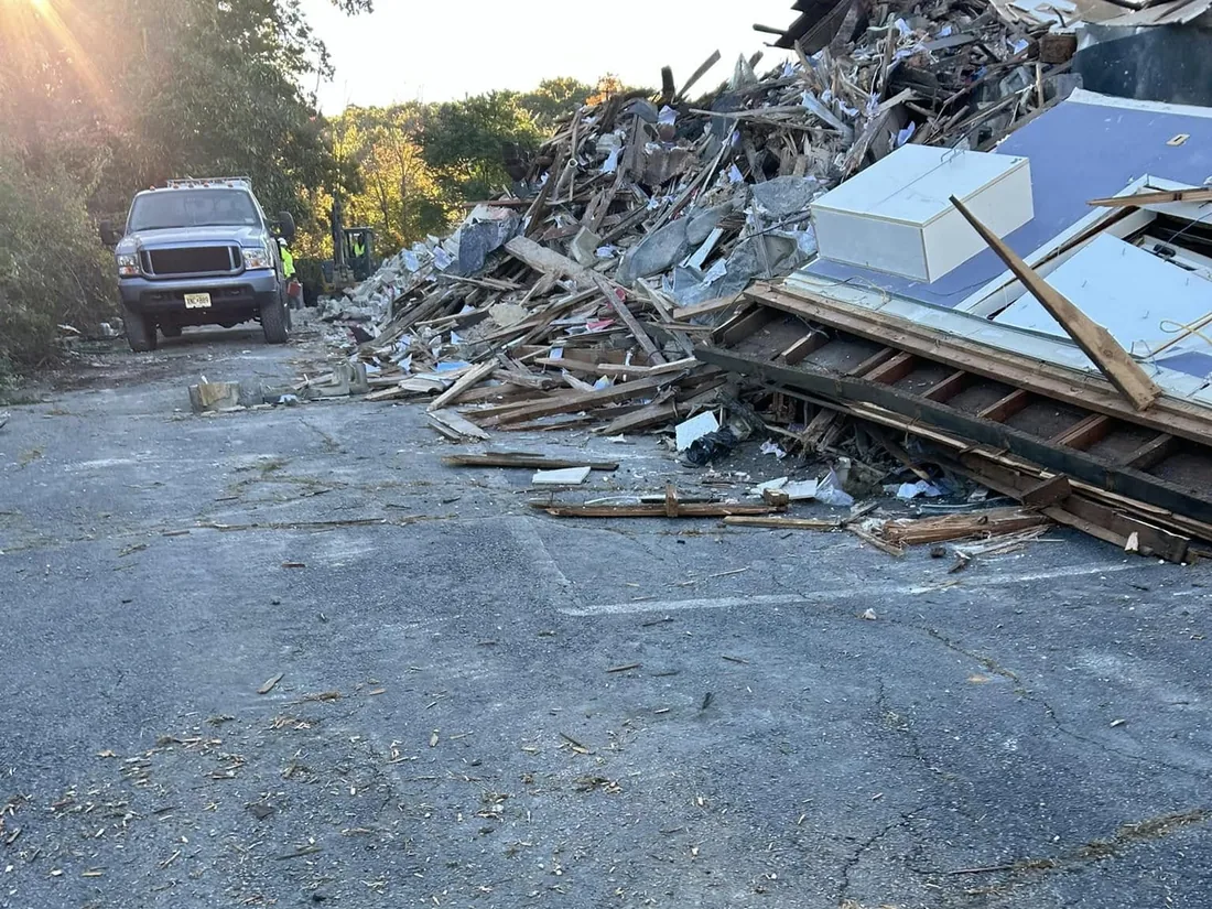 Teardown lot cleared to the asphalt with the last pile of debris at the back